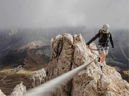 A roped climber working along a rocky ridge in the mist