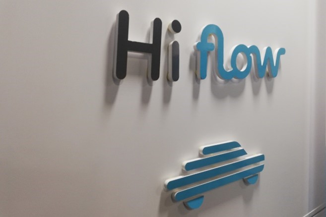 The Hiflow name in relief on a white wall, above the brand's pictogram
