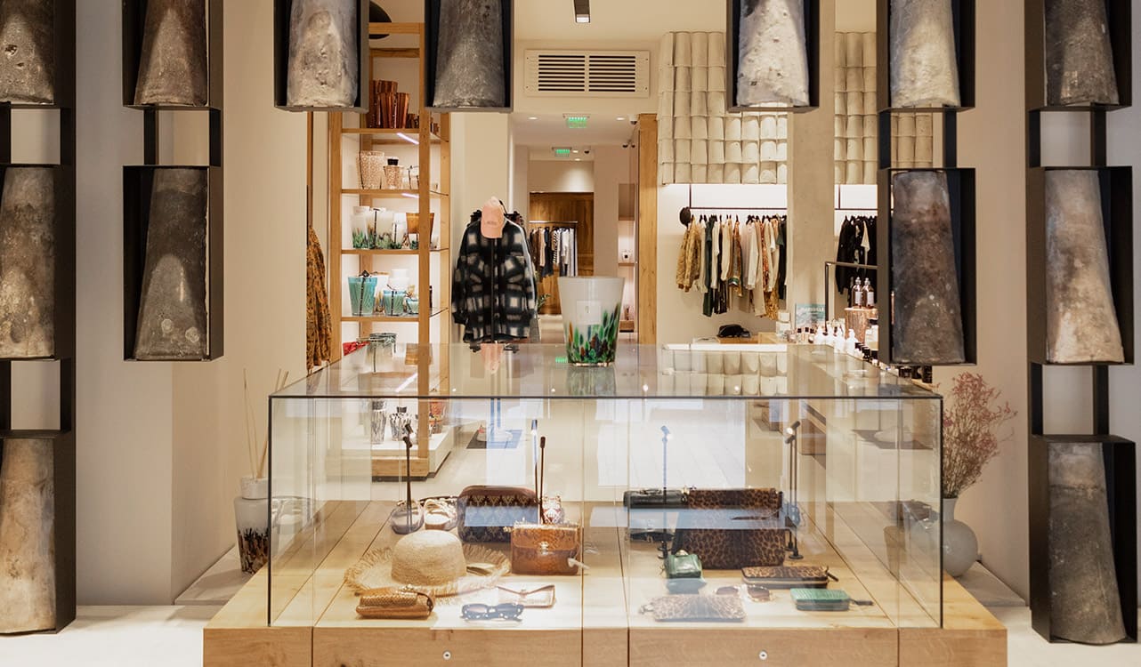 Inside a Lulli sur la Toile shop: an illuminated pale-wood star in front of the clothing rails